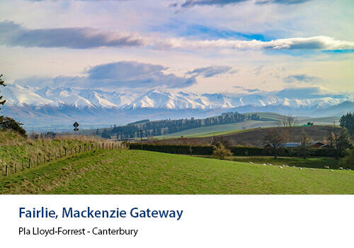 A lush green foreground leads into rolling hills and snow-covered peaks under a dramatic sky near Fairlie. Caption: Pia Lloyd-Forrest, Canterbury.