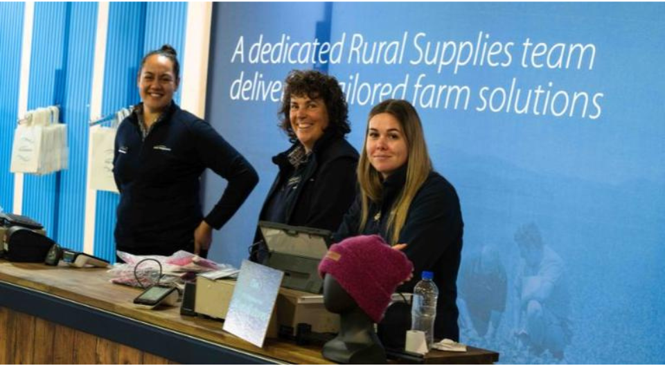 three retail store staff stand at the cash register