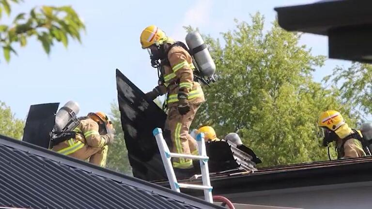 Firefighters on a roof.